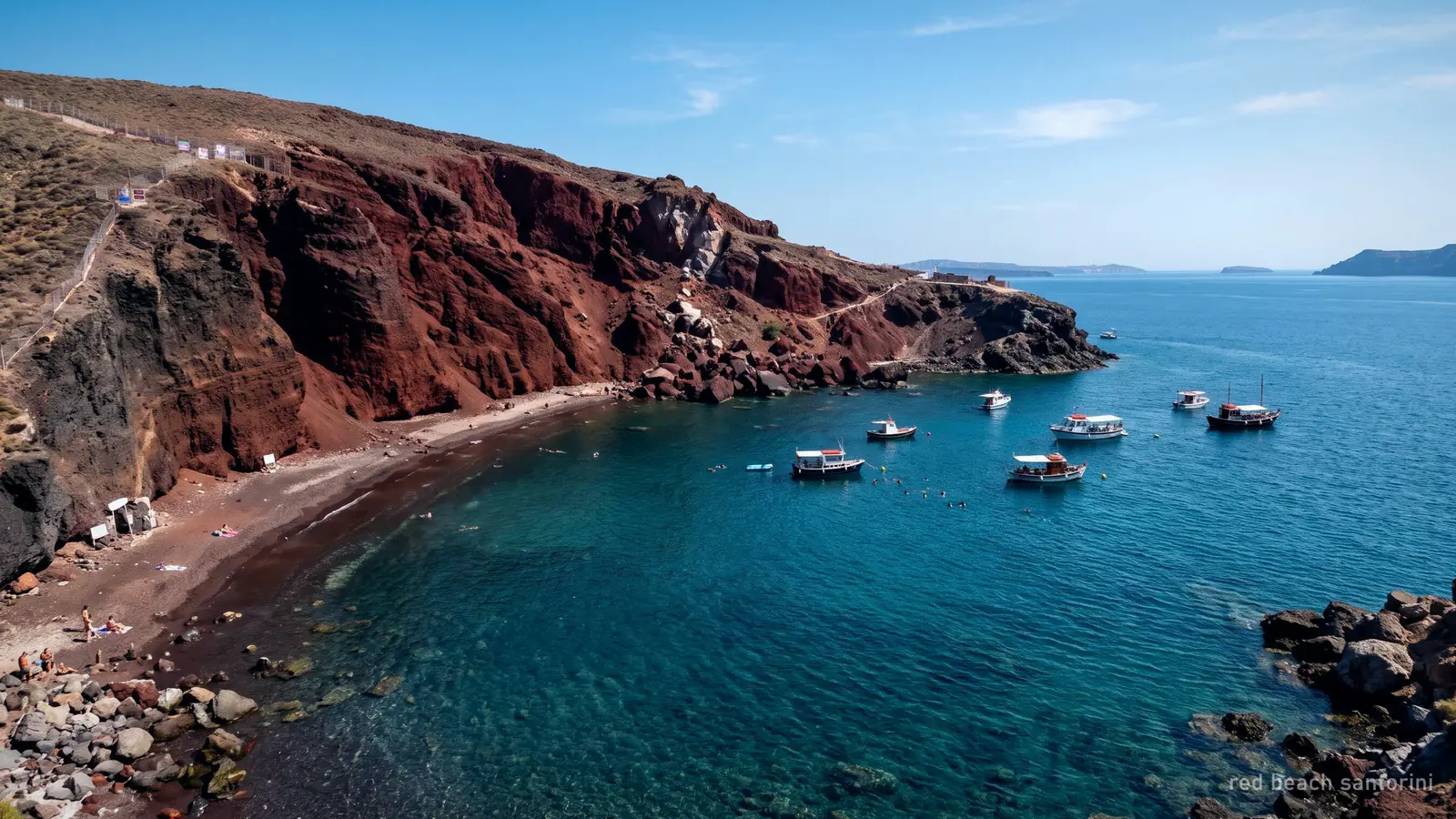 Red Beach near Akrotiri under its red volcanic cliff, boats anchored offshore