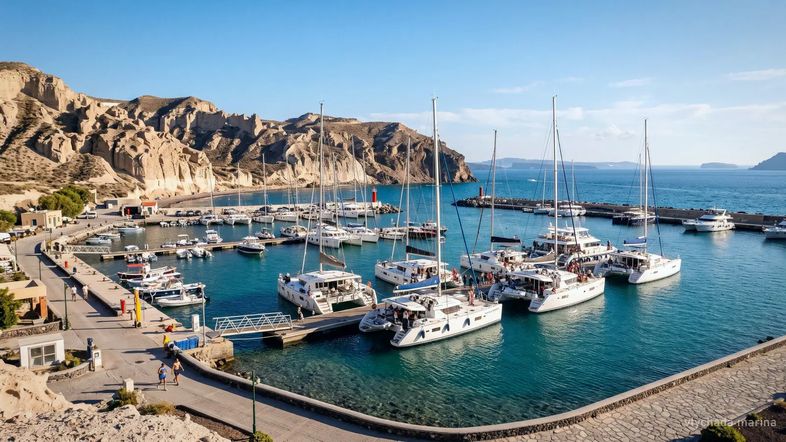 Vlychada Marina on the south coast of Santorini, yachts and catamarans moored below pale sandstone cliffs